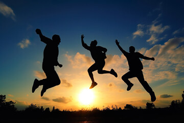 Fototapeta na wymiar jumping people silhouettes, Boundless Joy: Friends Leaping in the Air, Silhouettes Focused on Joints and Connections - A Bronze Smilecore Moment of Emotional Impact, Against a Sundown