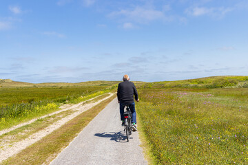 Tourist cycling at nature reserve Boschplaat at Wadden island Terschelling in Friesland province in The Netherlands