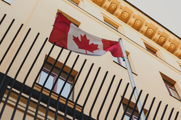 Flag of Canada on the background of the embassy