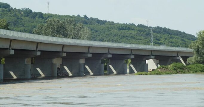 The landscape of the rushing river flow under highway bridge construction.