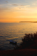 Small fishing boat illuminated by warm golden hour light. Beautiful sunset in Stobrec, small town near Split, Croatia.