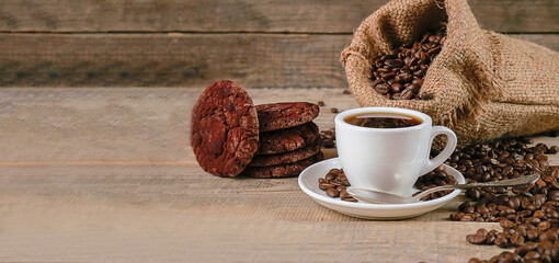 Fresh coffee. A cup of fresh aromatic coffee. Coffee cookies. Grains on a wooden background. Copy space. Banner