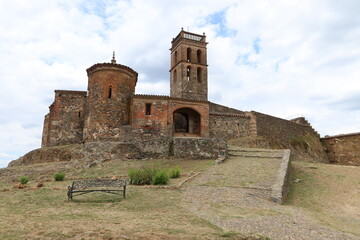 Almonaster la Real, Huelva, Spain, June 21, 2023: 13th century Romanesque apse, entrance door and minaret of the 10th century mosque of Almonaster la Real. Huelva, Spain