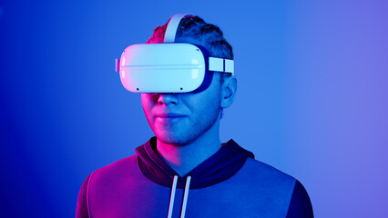 technology, online game, entertainment, virtual world in 3D simulation. millennial man in vr glasses plays in neon, studio shot, 3d render