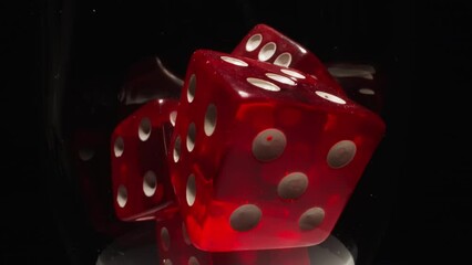Red dices with white dots thrown into transparent glass illuminated by bright studio light. Gaming cubes with equal points on faces in wineglass on black background macro - Powered by Adobe