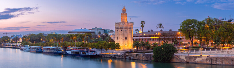 Sunset panorama over Seville, Guadalquivir river and golden tower Torre del Oro. - obrazy, fototapety, plakaty