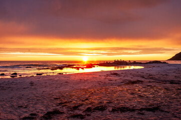 Sunset with illuminated water and sandy beach - Skagen, Lofoten, Norway.