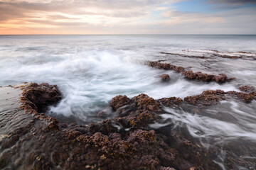 Sunset and cloudy sky over a rocky beach of HaBonim - Israel during sunset 