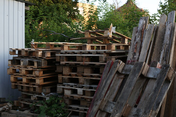 Old pallets. Wood waste dump. Boards and pallets on the street in the trash