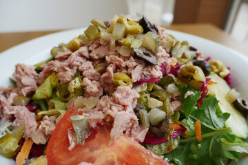 spoon pick tuna salad from a bowl on table 