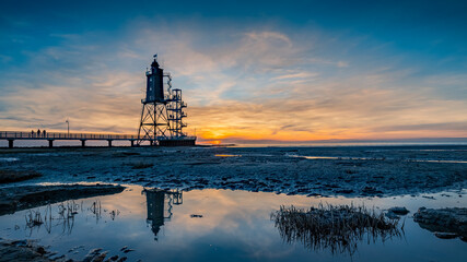 Obereversand lighthouse at sunset. Silhouette of the historic lighthouse Obereversand in Am...