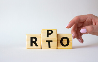 RPO vs RTO symbol. Businessman hand points at wooden cubes with words RTO and RPO. Beautiful white background. business concept. Copy space
