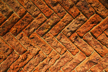 Diagonal pattern of an old red brick wall