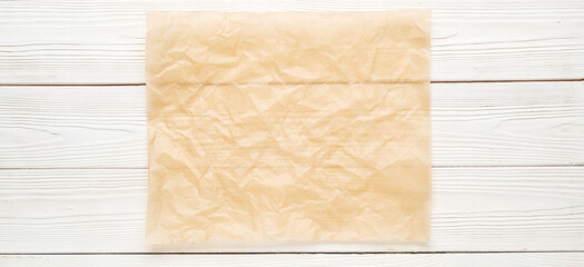 Sheet of baking paper on white wooden background