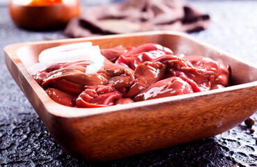Raw liver with onion in wooden bowl - Powered by Adobe