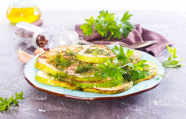 fried squash with oil and garlic on blue plate