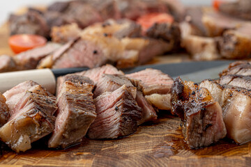 A steak on a cutting board with herbs and spices.Grilled beef tenderloin steak on a wooden board with grilled vegetables. Filet Mignon recipe concept, selective focus