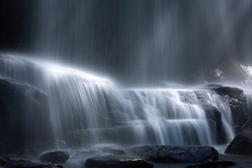 Obraz premium Fast moving waterfall cascade flowing down wet rocks