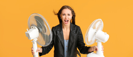 Screaming woman with electric fans on orange background