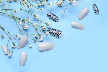 Press-on nails with flowers on blue background