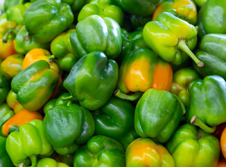 Many bell pepper on counter in grocery store closeup