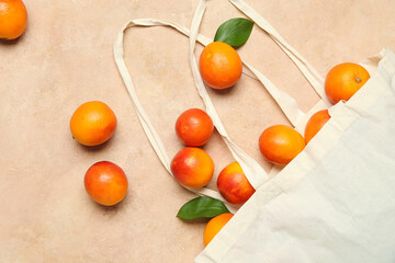 Eco bag with scattered tasty blood orange fruits on beige background