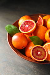 Bowl with delicious blood orange fruits on black grunge table