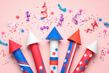 Obraz premium Firework rockets, confetti and serpentine for Independence Day on pink background