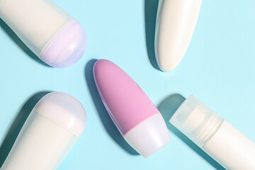 Different deodorant bottles on blue background