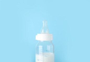 Bottle of milk for baby on blue background