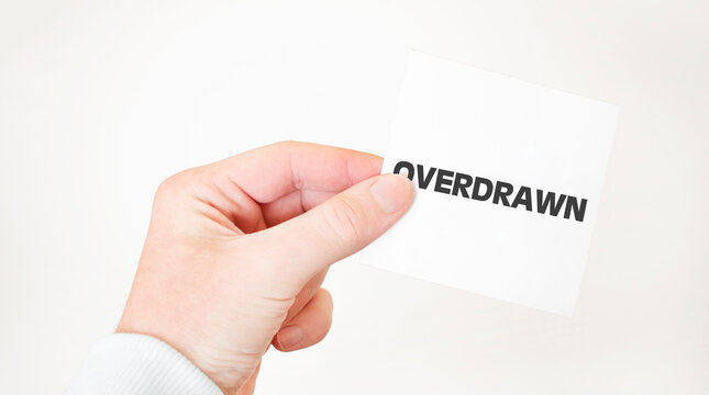 Businessman holding a card with text overdrawn business concept