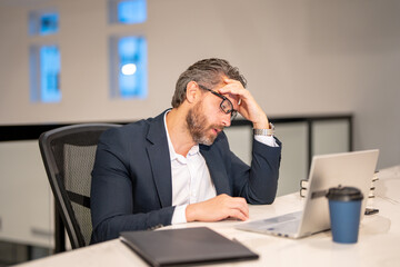 Naklejka premium Modern office. Tired sad caucasian business man in business suit using laptop, working remotely, e-commerce online at office. Finance auditor. Ceo manager employee having business idea. Business