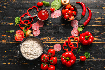 Frame made of fresh ingredients for preparing pizza on dark wooden background