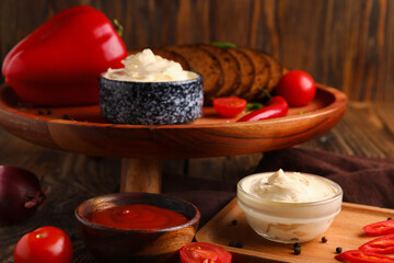 Obraz na płótnie Canvas Bowls of tasty cream cheese and sauce on table