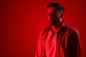Obraz premium Young man having panic attack on red background