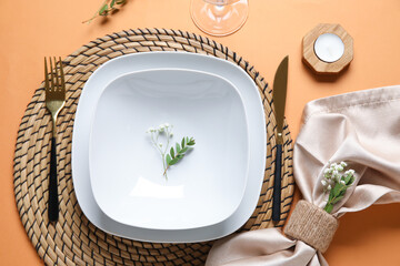 Beautiful table setting with candle and gypsophila flowers on beige background, closeup