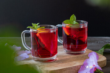 Red Hot Hibiscus tea in a glass mug on a wooden table 
