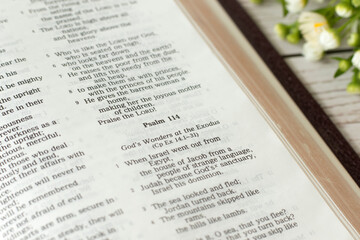 Psalm 114, open holy bible book on wooden table. A close-up. God's wonders, salvation, and...
