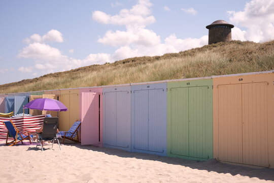 Beach in Domburg Netherlands,colorful beachhouse and blue sky. Men sitting under purple umbrella on the beach .High quality photo