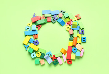 Frame made of wooden letters and colorful blocks on green background. Children's Day celebration