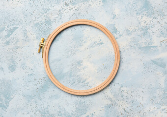 Wooden embroidery hoop on grunge blue background