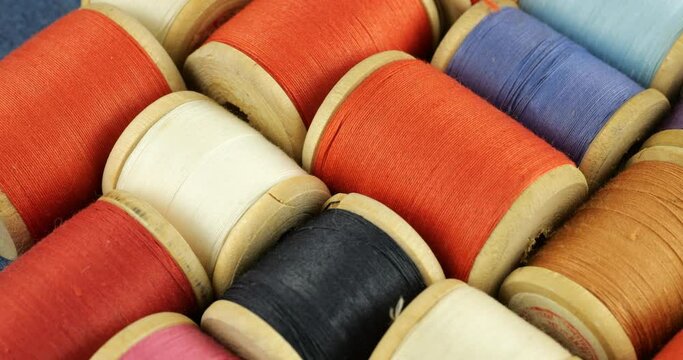 Vintage wooden spools with cotton threads in different colors.