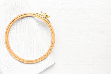 Wooden embroidery hoop with canvas on white wooden background © Pixel-Shot