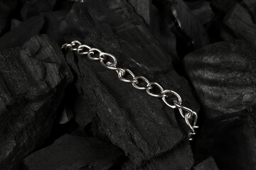 Beautiful chain bracelet on black charcoal, closeup