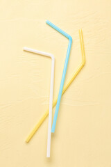 Different colorful straws on pale yellow background