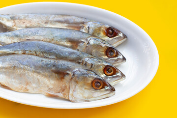 Salted fish on yellow background.