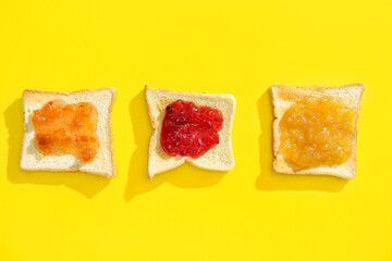 Tasty toasts with jams on yellow background