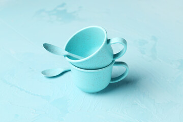 Cups and spoons for baby on grunge blue background