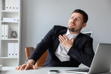 Young businessman having panic attack in office