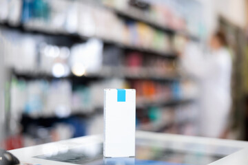 Box with cosmetics or healing cream on cash desk, against background of showcase with products in a pharmacy